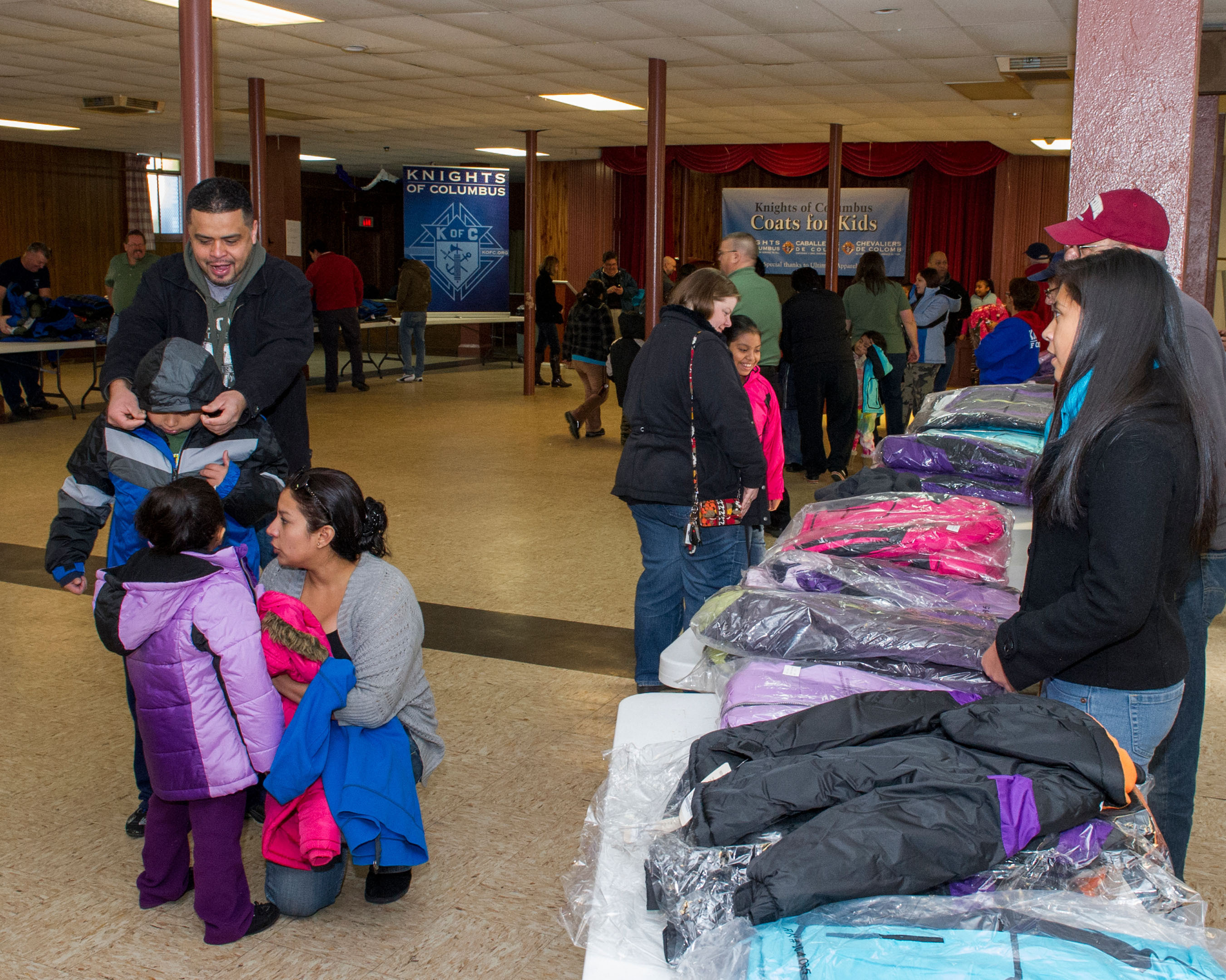 Children - accompanied by their parents - receive free winter coats from the Knights of Columbus at St. Rose Church in New Haven.More than 2000 coats were distributed statewide by the Knights of Columbuson Friday, Nov. 29. (PRNewsFoto/Knights of Columbus) (PRNewsFoto/KNIGHTS OF COLUMBUS)