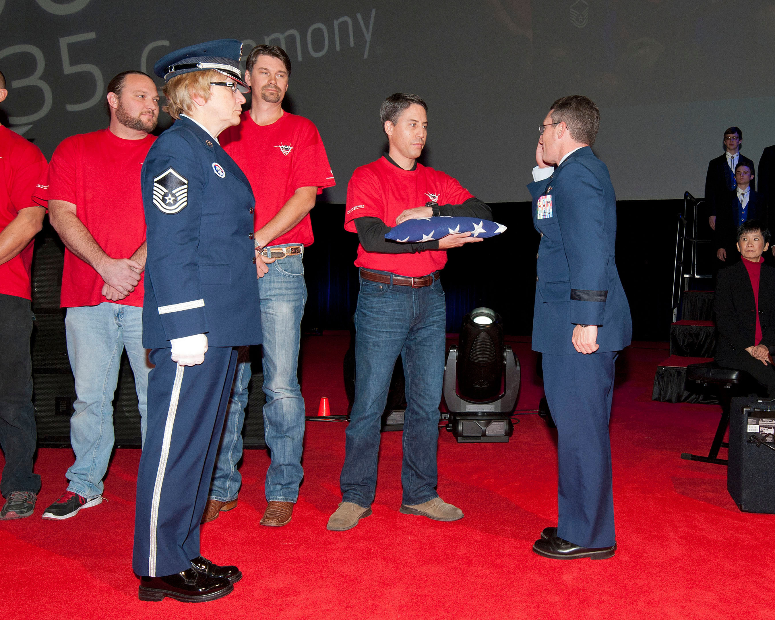 Brig. Gen. Michael Rothstein accepts commemorative U.S. flag from Chris Felton, a Lockheed Martin F-35 production employee, at the 100th F-35 Inauguration. (PRNewsFoto/Lockheed Martin Aeronautics Company) (PRNewsFoto/LOCKHEED MARTIN AERONAUTICS ...)