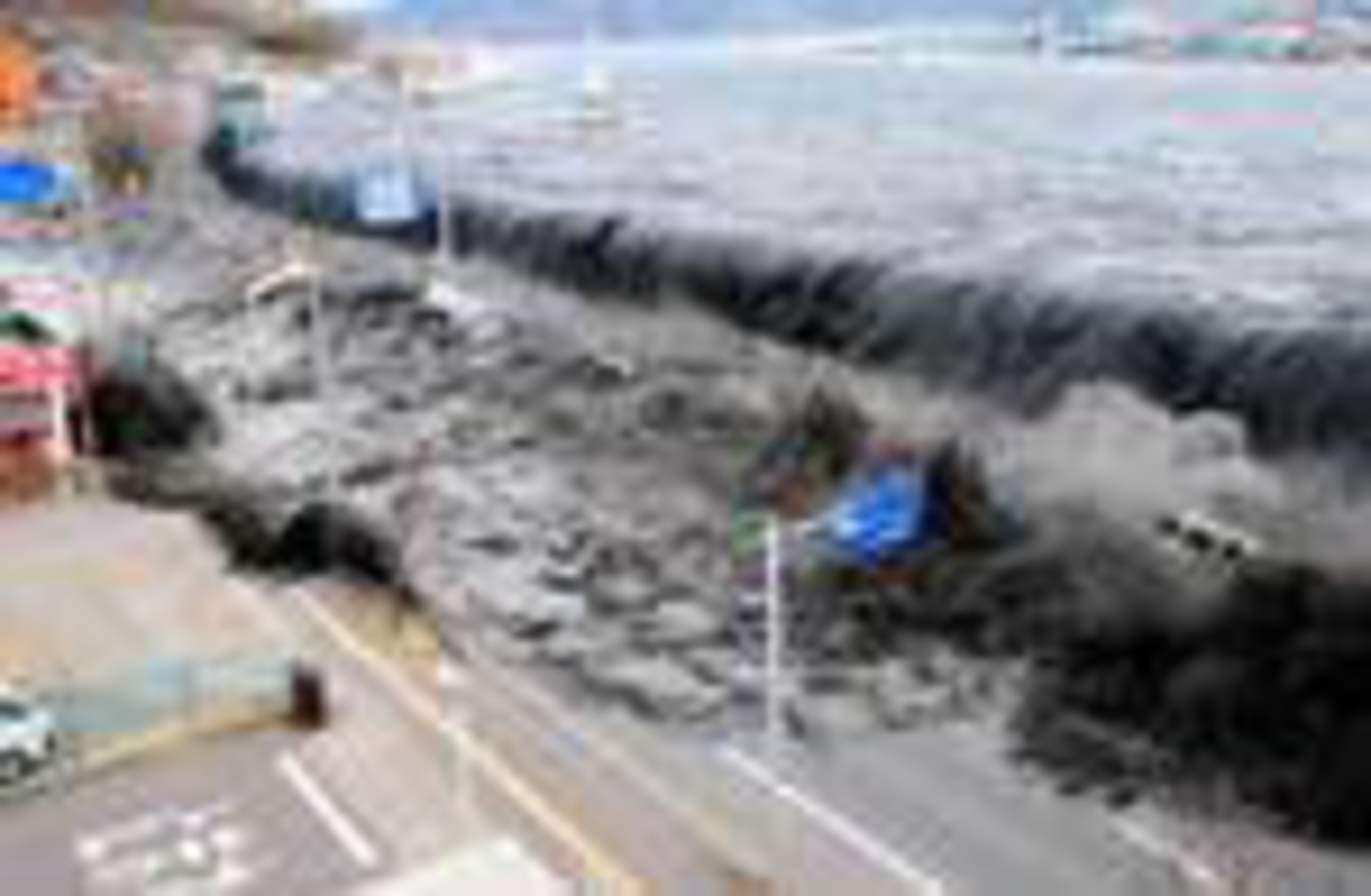 Tsunami overwhelms barrier of Miyako City on March 11, 2011...one of 200 such barriers that failed on that fateful day. (PRNewsFoto/The Hiroshima Syndrome) (PRNewsFoto/THE HIROSHIMA SYNDROME)