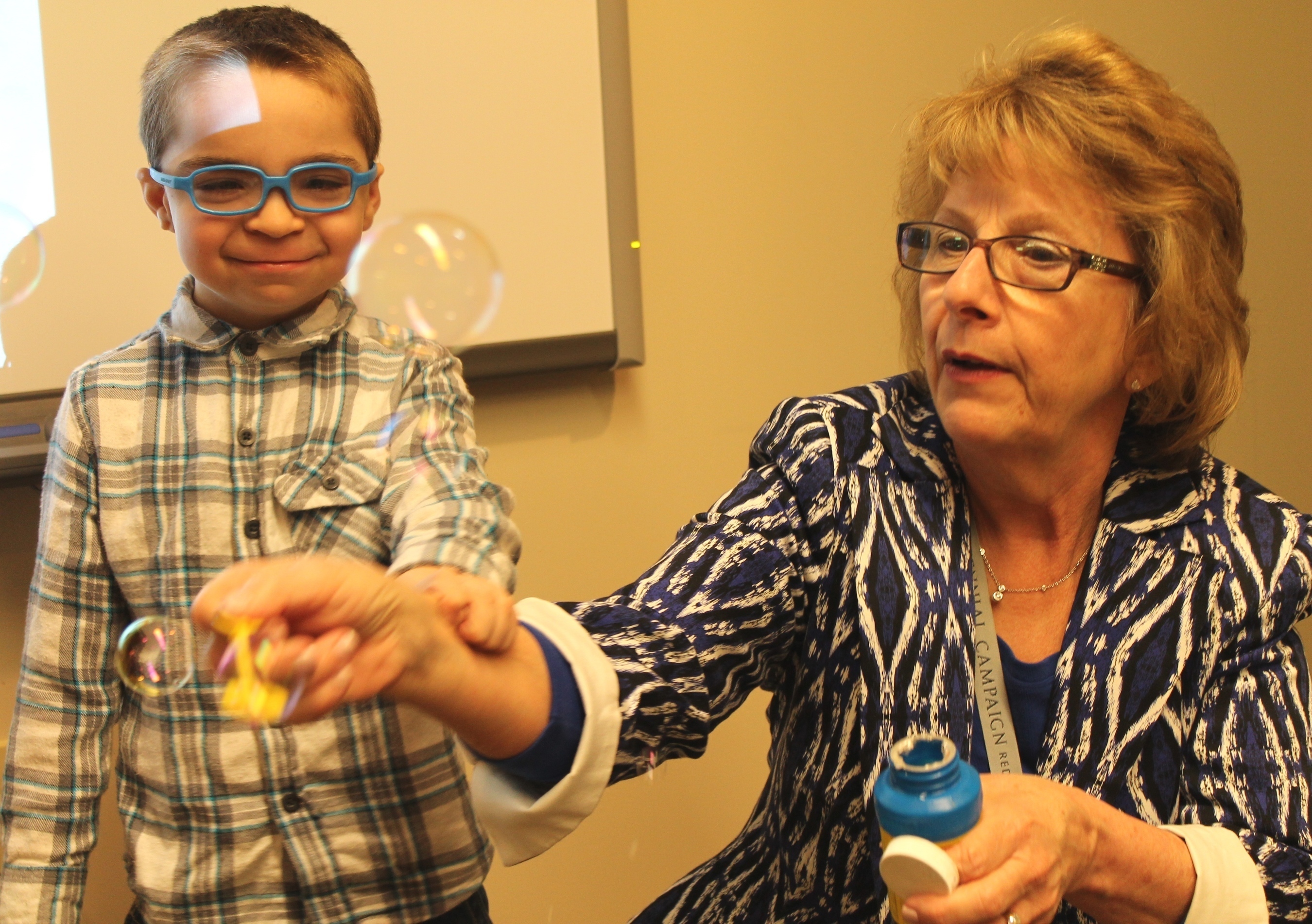 Barbara Haas-Givler, M.Ed., BCBA, trainings and consultative services/behavior consultant, ADMI, blows bubbles with 5-year-old patient Kaleb Miller during a recent visit to the Geisinger-Bucknell Autism & Developmental Medicine Center in Lewisburg, Pa. (PRNewsFoto/Geisinger Health System)