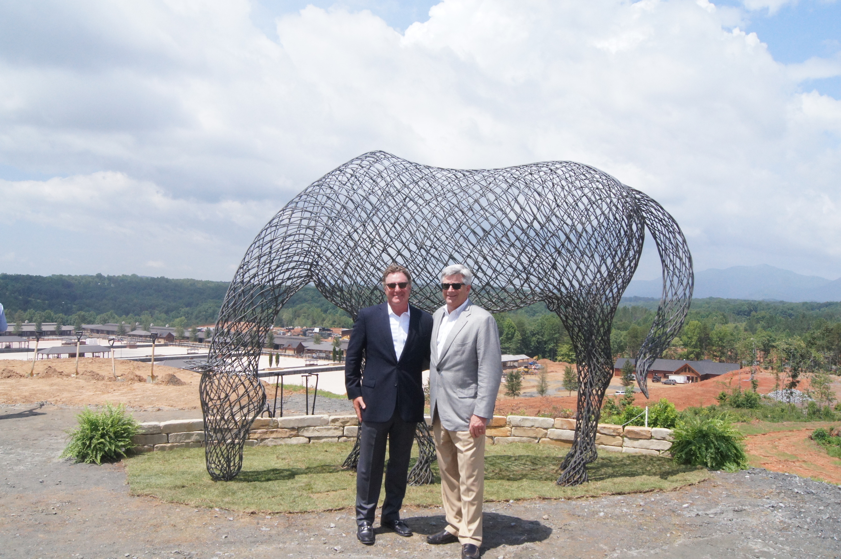 Managing Partner of Tryon International Equestrian Center, Mark Bellissimo and Chip Smith, President/Owner of Blue Ridge Log Cabins stand in front of a metal horse sculpture at the projects ground breaking press conference on Wednesday, June 25th. (PRNewsFoto/Blue Ridge Log Cabins)