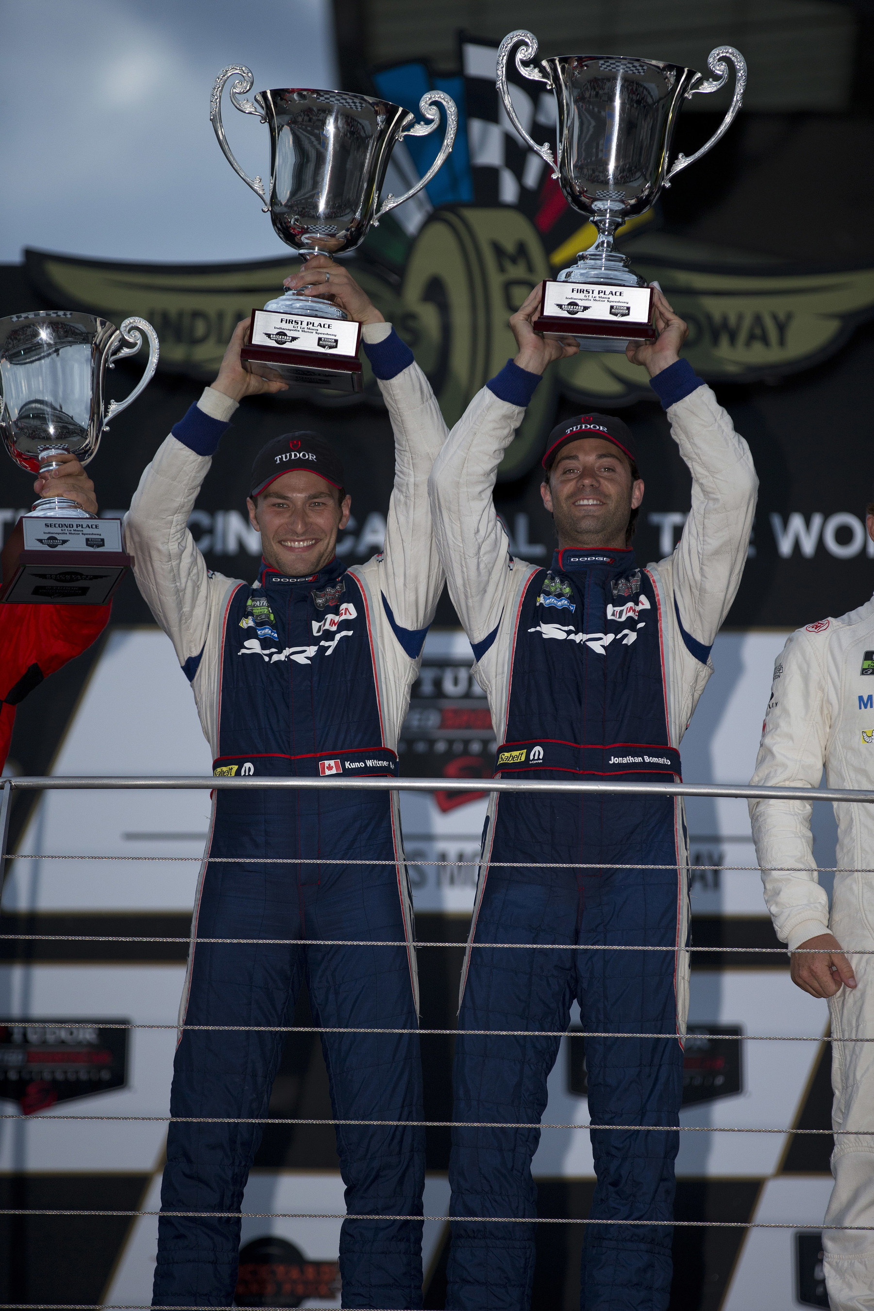 Drivers Kuno Wittmer, left, and Jonathan Bomarito hoist the winner trophies and celebrate after piloting the No. 93 Dodge Viper SRT GTS-R race car to a first-place finish in the GTLM class in the IMSA TUDOR United SportsCar Championship Brickyard Grand Prix on Friday, July 25, 2014. (PRNewsFoto/Chrysler Group LLC) (PRNewsFoto/Chrysler Group LLC)