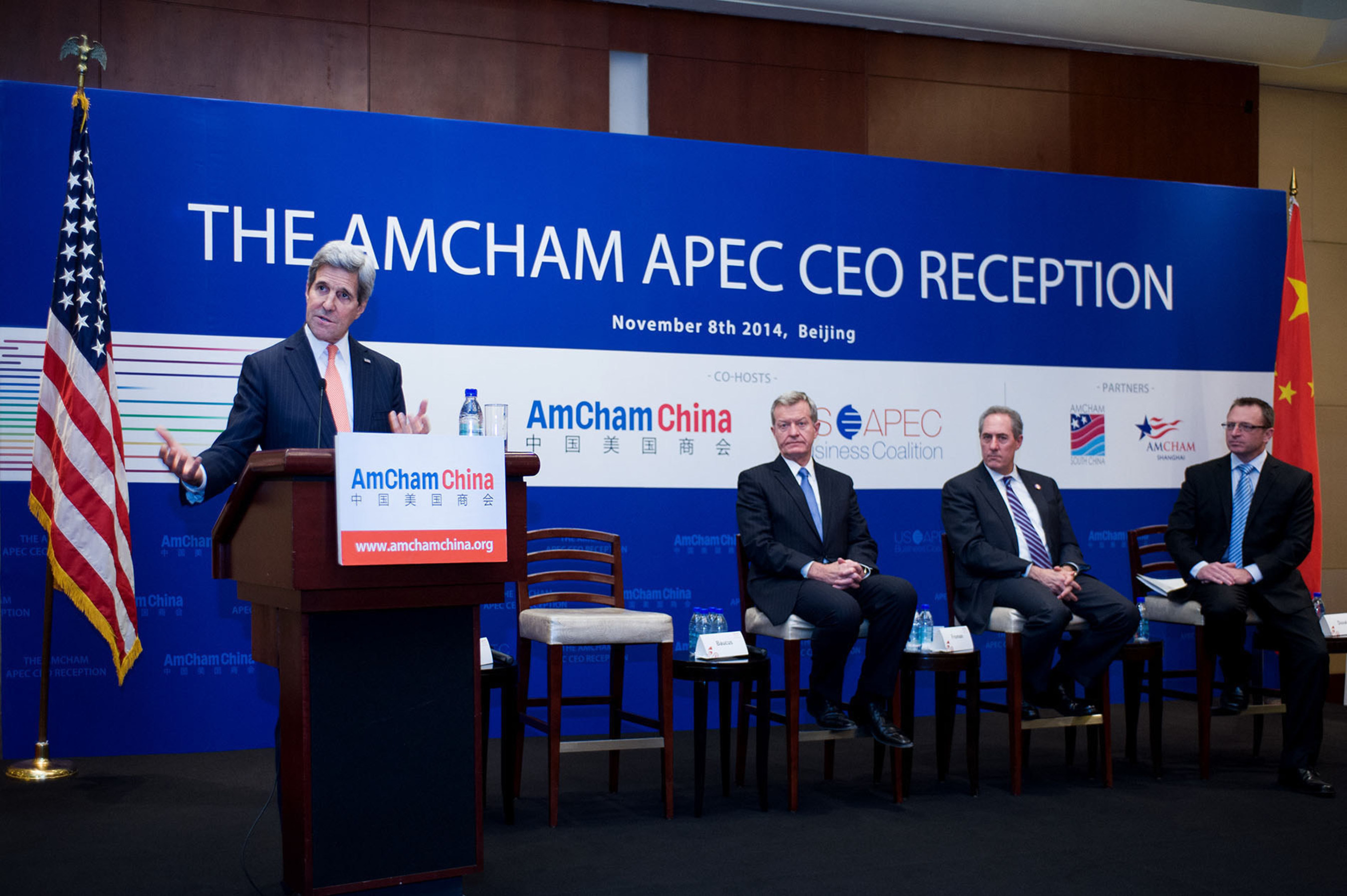 US Secretary of State John Kerry addresses The AmCham APEC CEO Reception in Beijing, watched by US Ambassador to China Max Baucus, US Trade Representative Michael Froman, and American Chamber of Commerce in China President Mark Duval. Photo: AmCham China