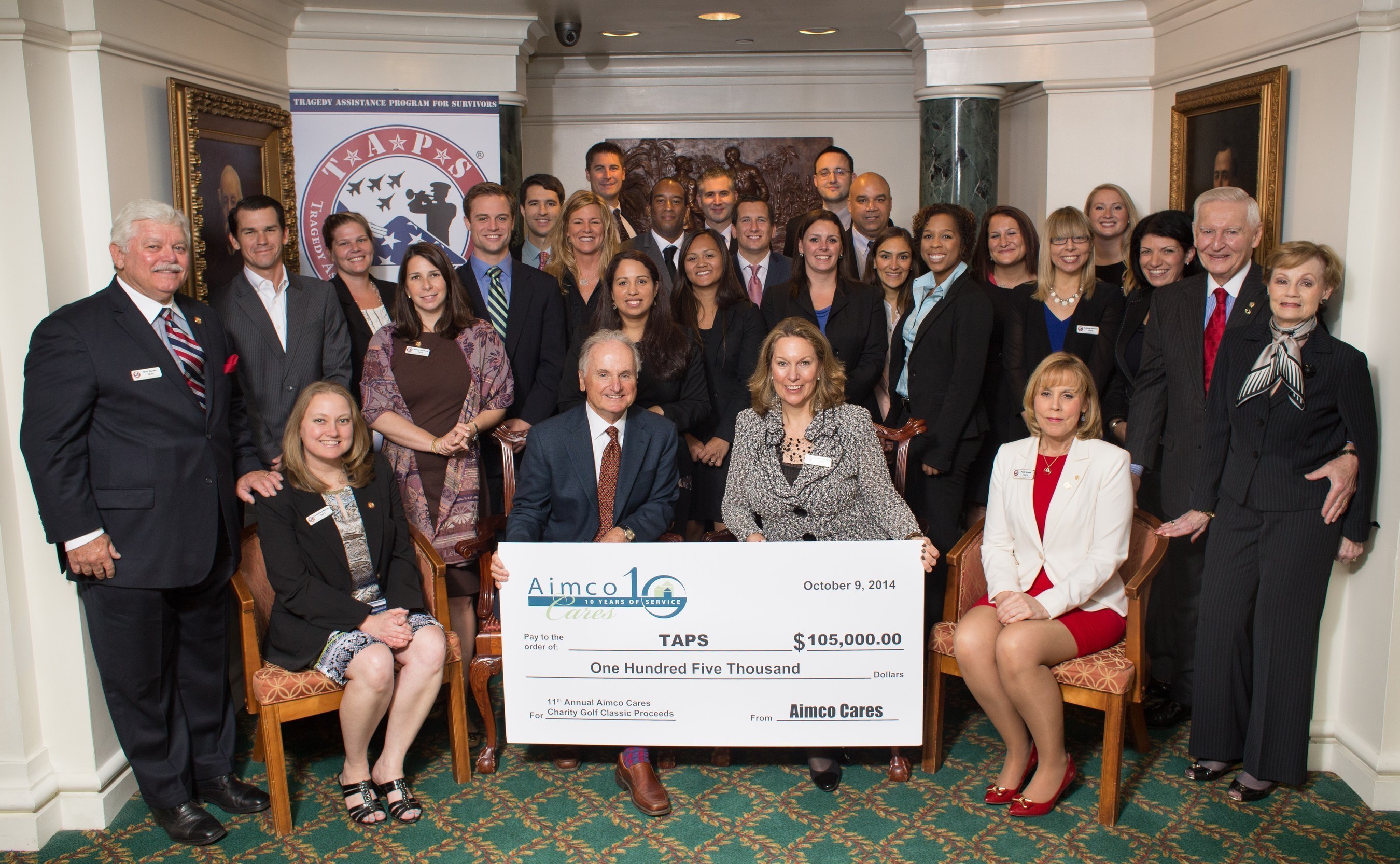 Aimco Chief Administrative Officer Miles Cortez and TAPS Founder and President Bonnie Carroll hold a ceremonial check representing Aimco's $105,000 donation to TAPS. They were joined by TAPS leadership, 15 members of the Aimco DC team, and Brian Bradford of RentPath, a major tournament sponsor.