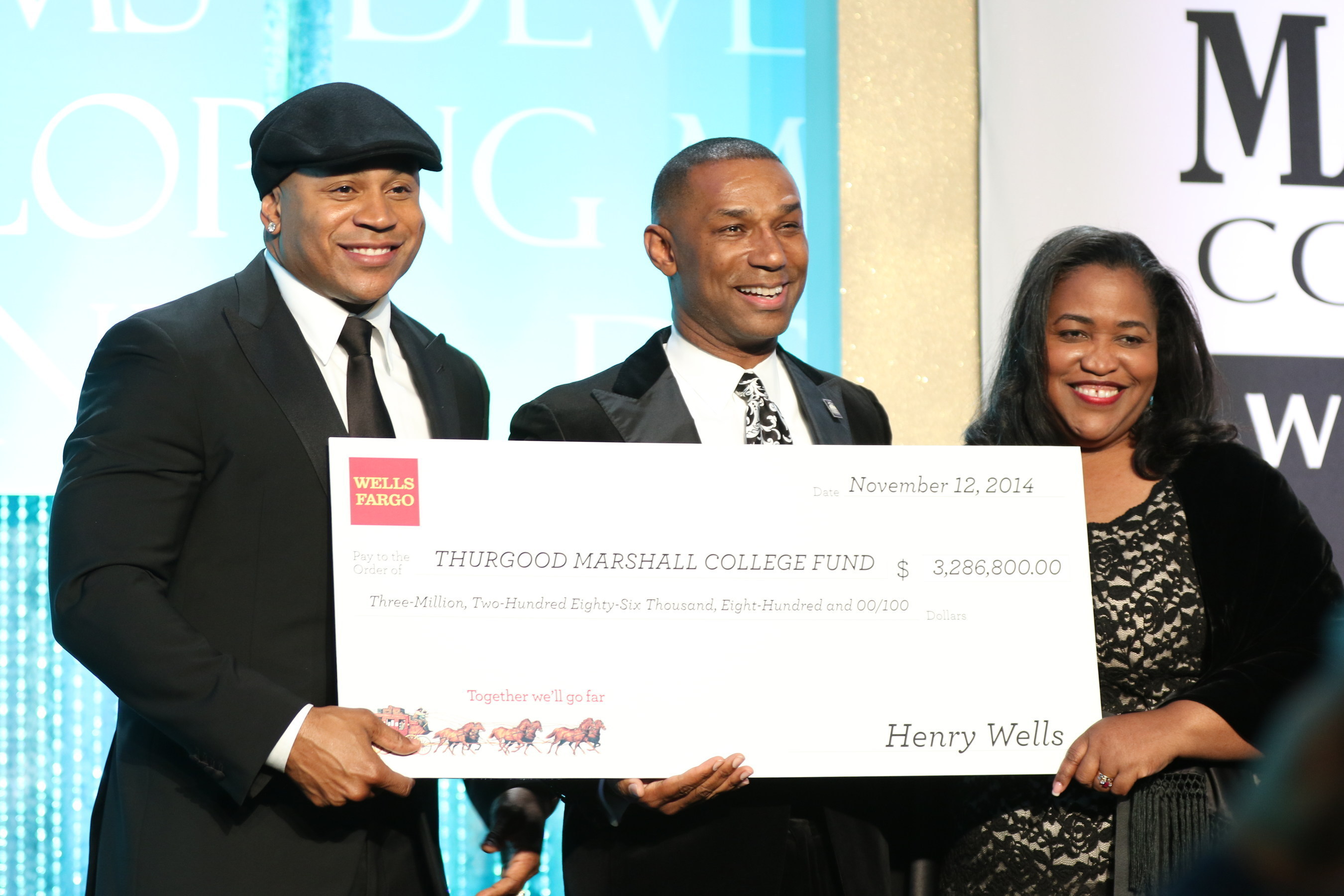 TMCF President & CEO Johnny C. Taylor, Jr. receives check from Wells Fargo