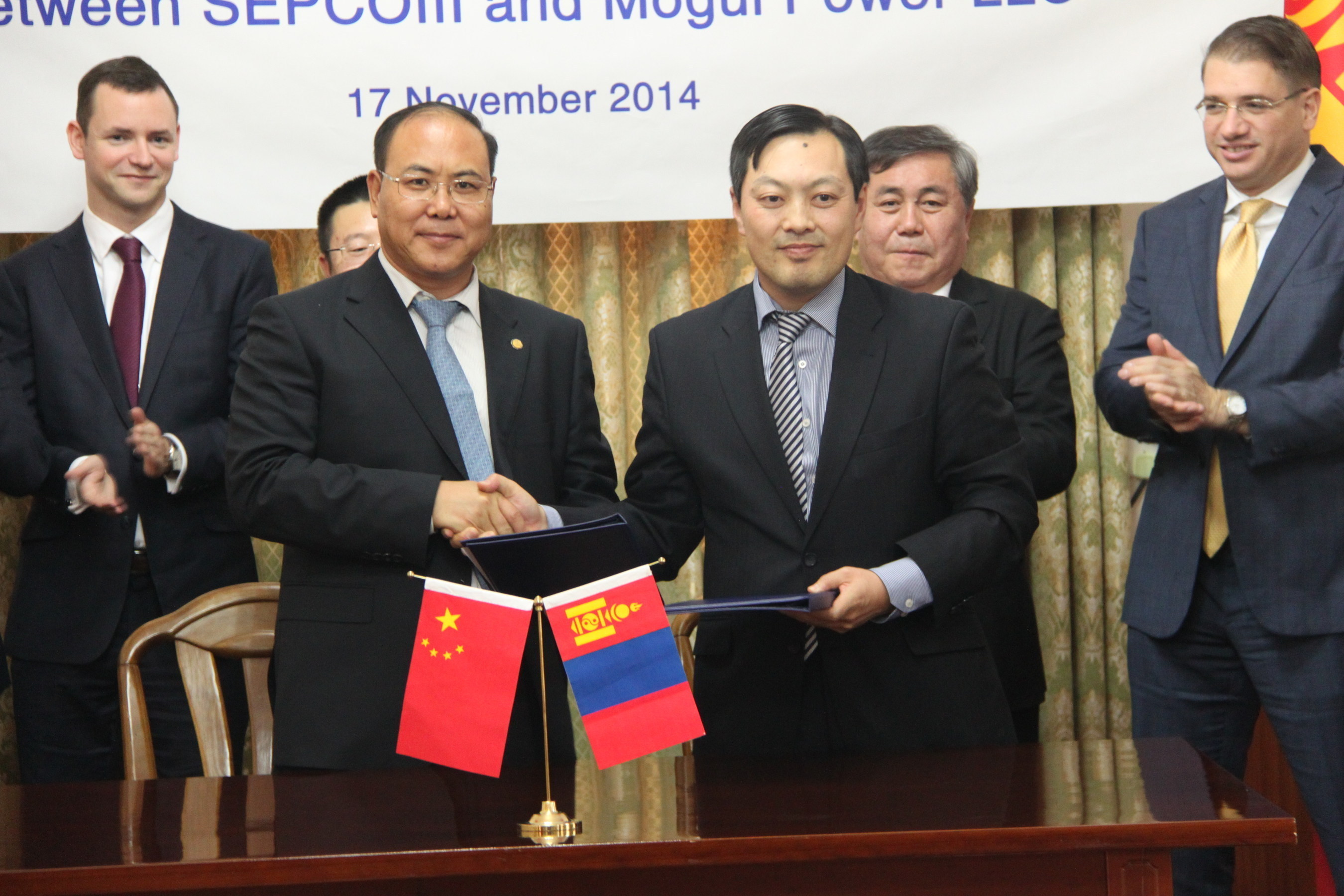 In the presence of Ambassador Sukhbaatar Ts., Mr. Zhang Hongsong, Vice President of SepcoIII (left) and Mr. Erdembileg J., CEO of Mogul Power LLC (right) celebrate the signing of the agreement.
