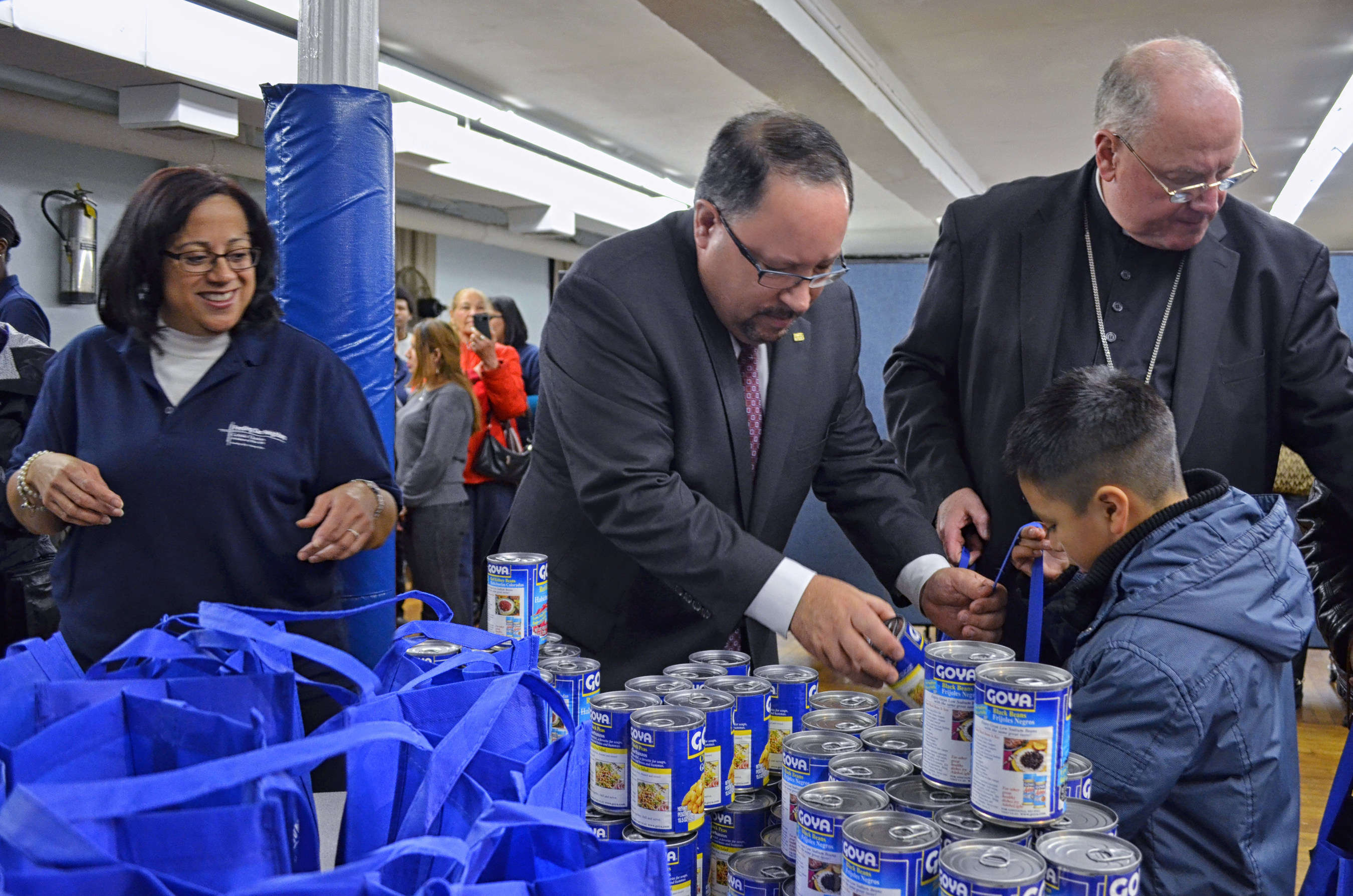 President Bob Unanue of Goya Foods, Cardinal Dolan and Catholic Charities of NY help pack 300,000 pounds of Goya products into bags to give to the hungry and unaccompanied children throughout New York City and the United States.