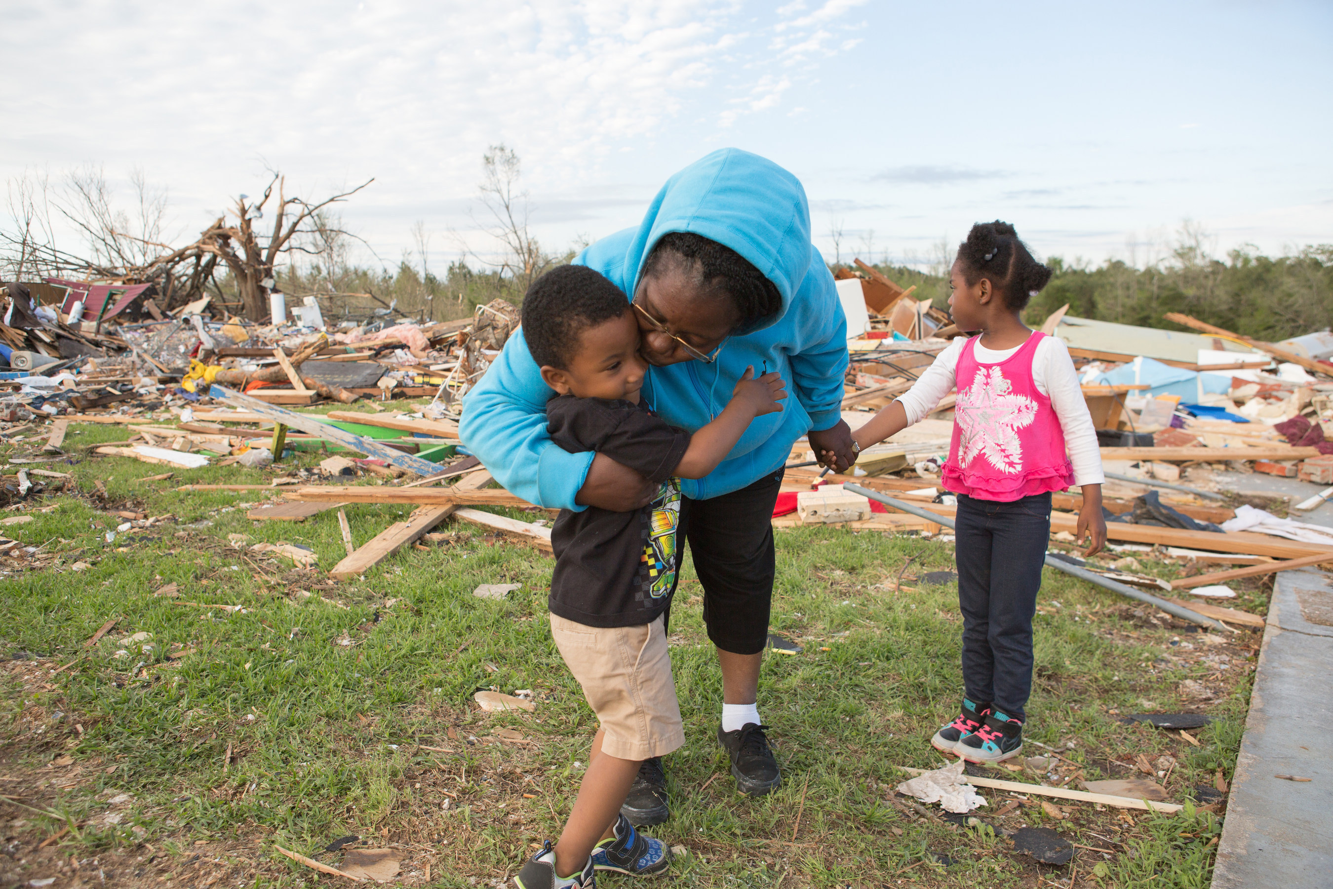 Destiny's Daycare Director Deborah Holmes comforts her Jaquan, 3 and Breanna, 5, after an April 2014 tornado destroyed their Louisville, Miss. child care center. Mississippi is one of 31 states that currently meet three child care emergency planning standards tracked by Save the Children annually. A new federal law means 19 lagging states will also need to meet the standards. Credit: Amie Vanderford/Save the Children.