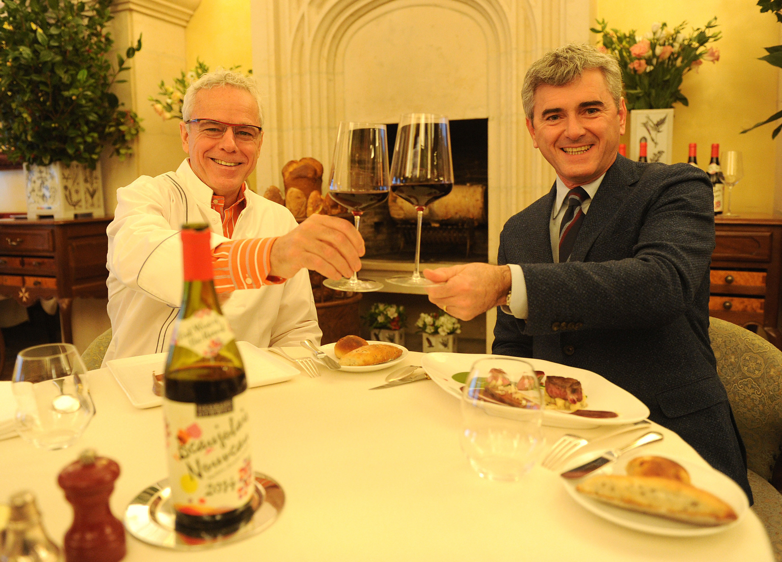 Franck Duboeuf, right, and chef David Bouley celebrate the arrival of the 2014 Georges Duboeuf Beaujolais Nouveau in the U.S., Wednesday, Nov. 19, 2014, at Bouley in New York.  According to French law, the wine is released on the third Thursday of each November.  (Photo by Diane Bondareff/Invision for Les Vins Georges Duboeuf)