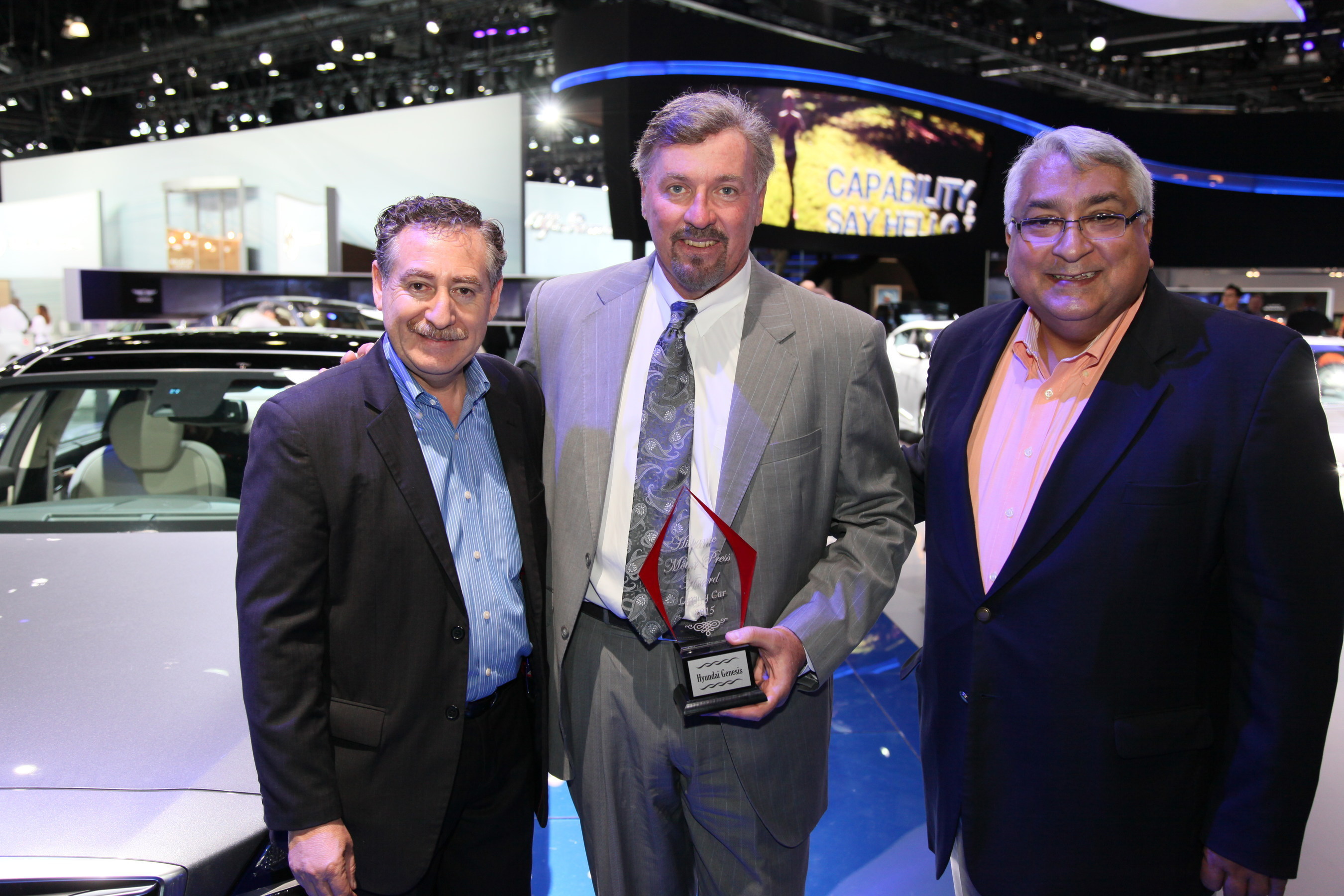 Ricardo Rodriguez-Long (left) and Jaime Florez (right) present the Hispanic Motor Press Award "Best Luxury Car" for the 2015 Genesis to Dave Zuchowski, president and CEO, Hyundai Motor America (center).