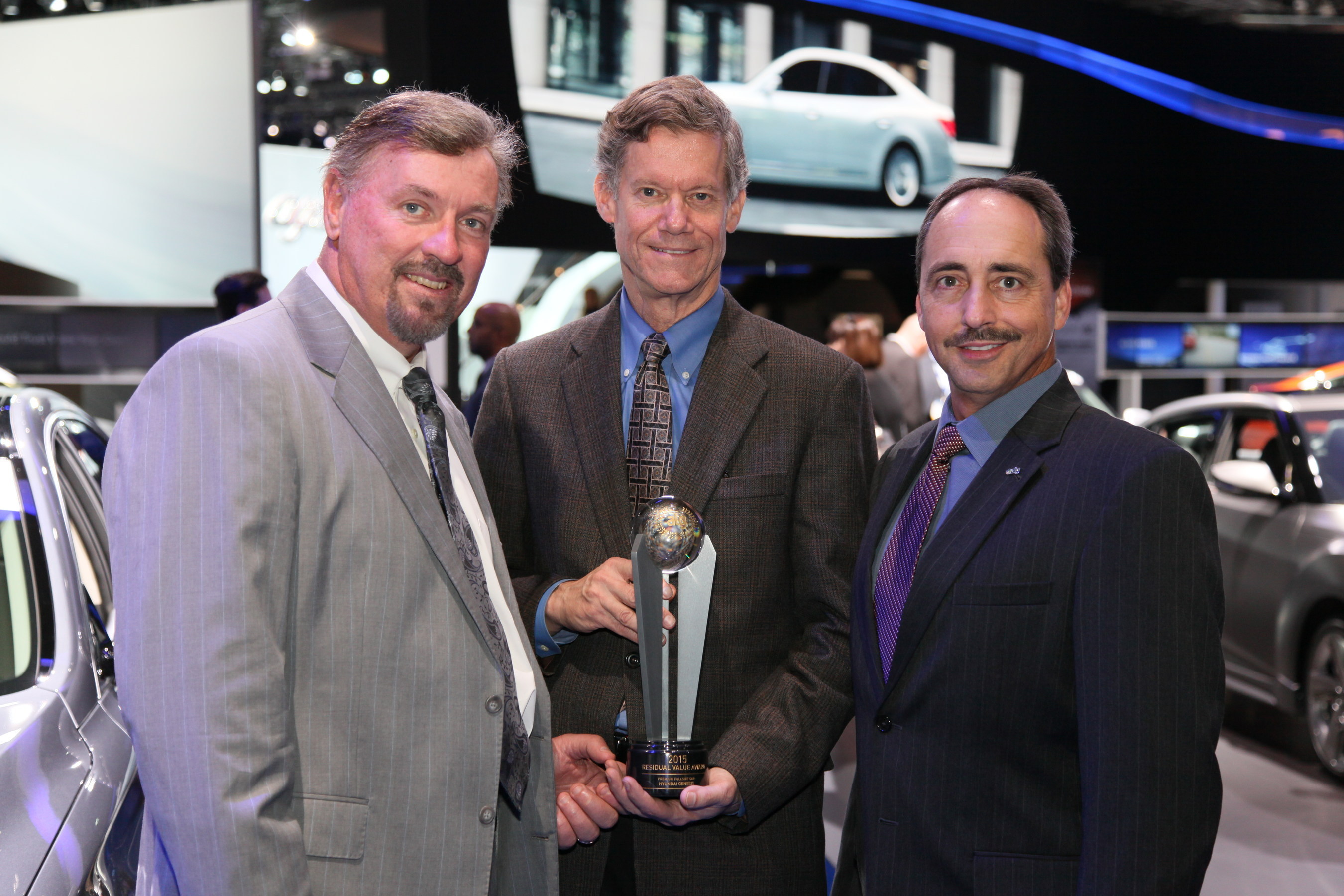 Larry Dominique, president, ALG hands the ALG Best Residual Value award for the Premium Full-Size Car Segment that 2015 Genesis won to Dave Zuchowski, president and CEO, Hyundai Motor America and Mike O'Brien, vice president, corporate and product planning, Hyundai Motor America (center).