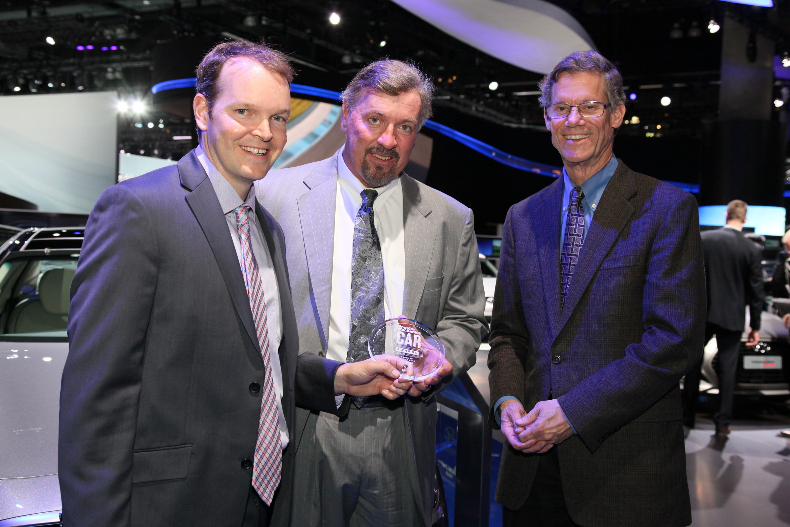 Ezra Dyer, automotive editor, Popular Mechanics, presents the Popular Mechanics "Luxury Car of the Year" award to Dave Zuchowski, president and CEO, Hyundai Motor America (center) and Mike O'Brien, vice president, corporate and product planning, Hyundai Motor America.