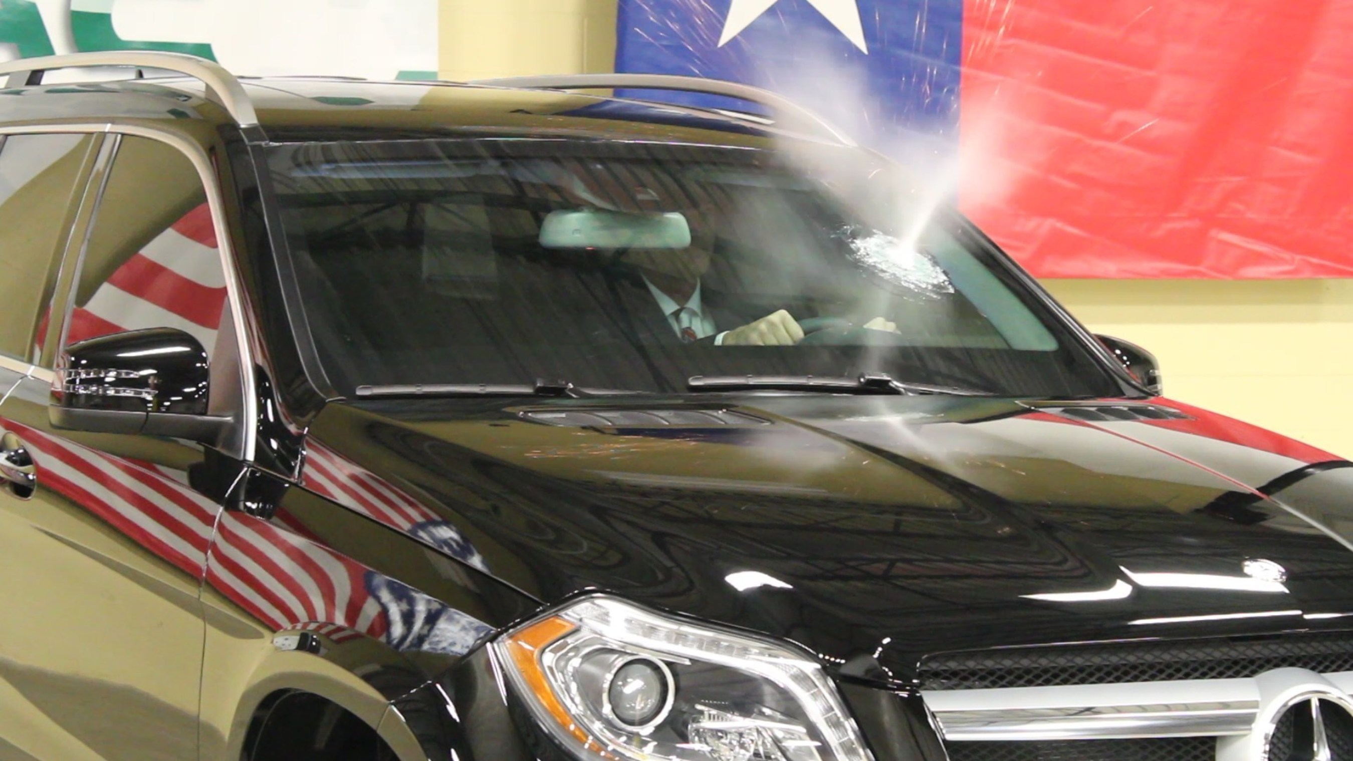 The first bullet fired from an AK-47 strikes the windshield of an armored Mercedes-Benz SUV just inches from Texas Armoring President/CEO Trent Kimball's face.