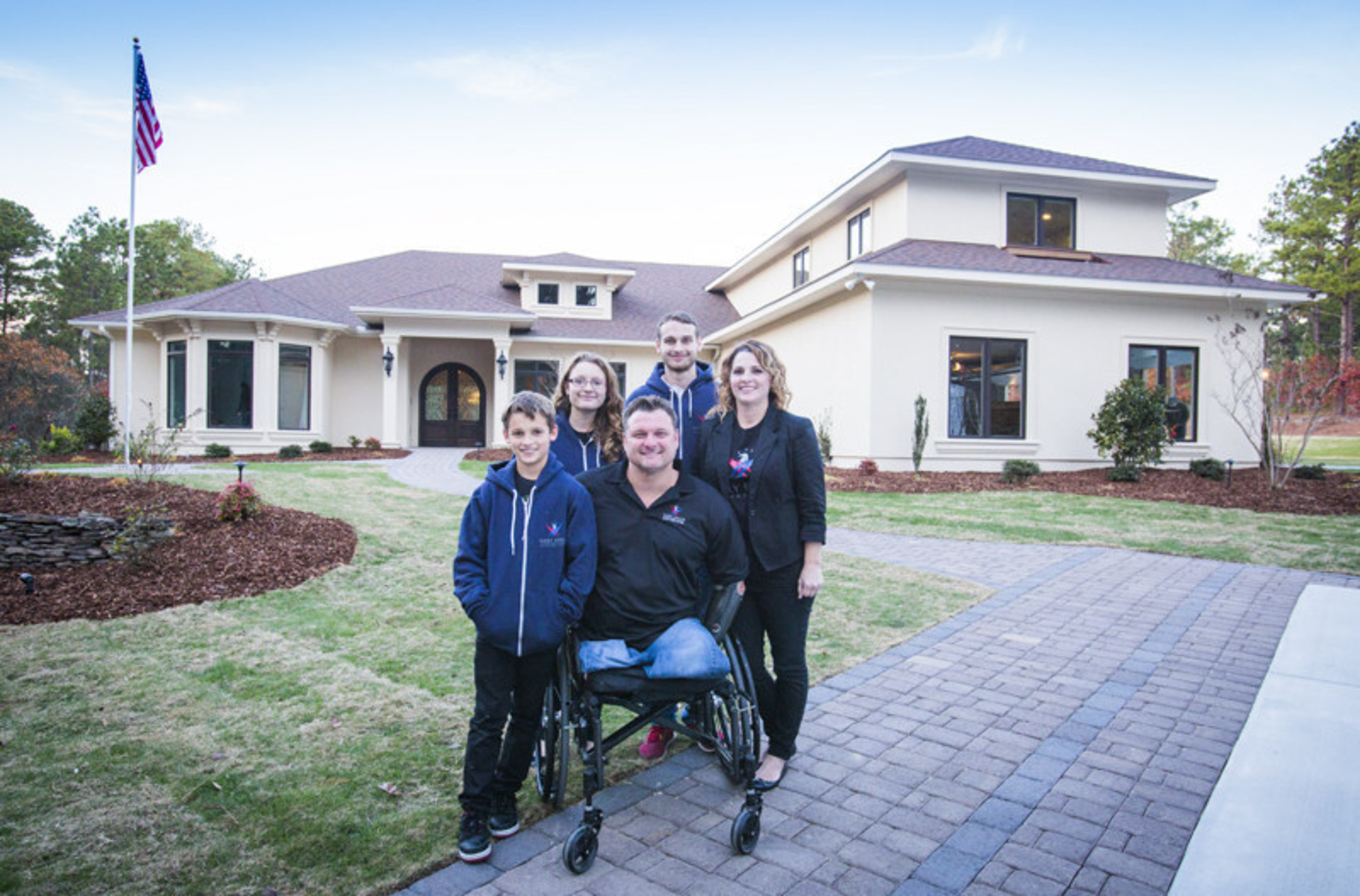 Triple amputee MSG John Masson and his family outside their new specially adapted Smart Home in Southern Pines, North Carolina, courtesy of Building for America's Bravest - a partner program between the Gary Sinise Foundation's R.I.S.E. program and Stephen Siller Tunnel To Towers Foundation
