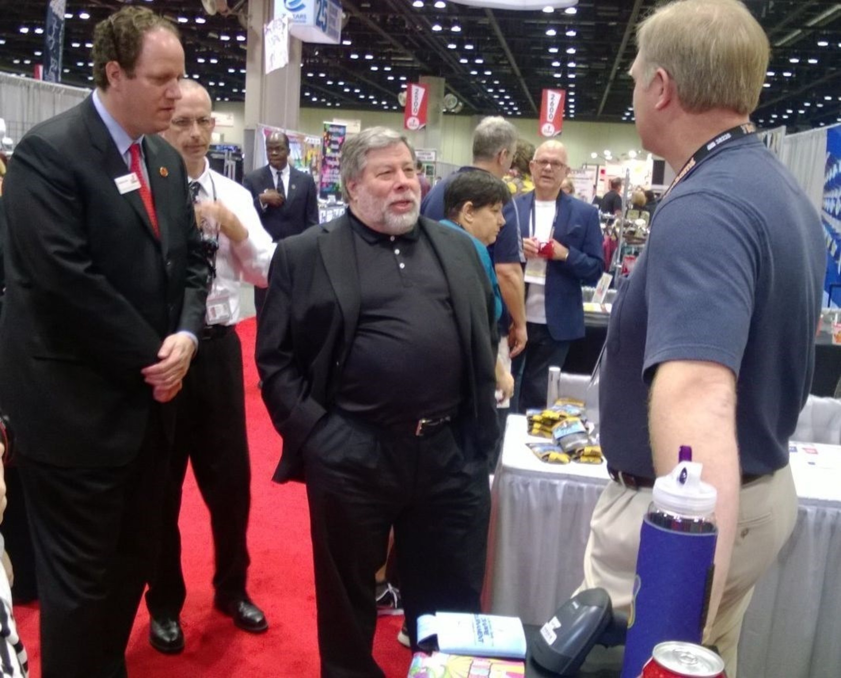 Apple co-founder Steve Wozniak, center, tours the show floor at ASI Show Orlando Tuesday with ASI vice-chairman Matthew Cohn, far left, after a keynote Q&A before a packed house of promotional products suppliers and distributors.