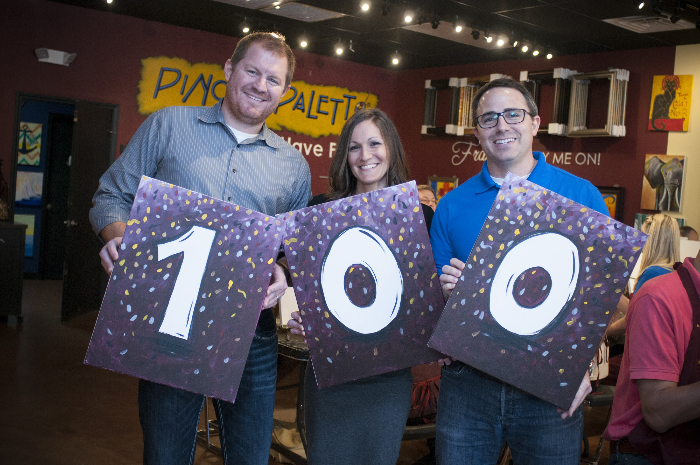 Pinot's Palette co-founders Charles Willis, Beth Willis and Craig Ceccanti celebrate their 100th studio signing.