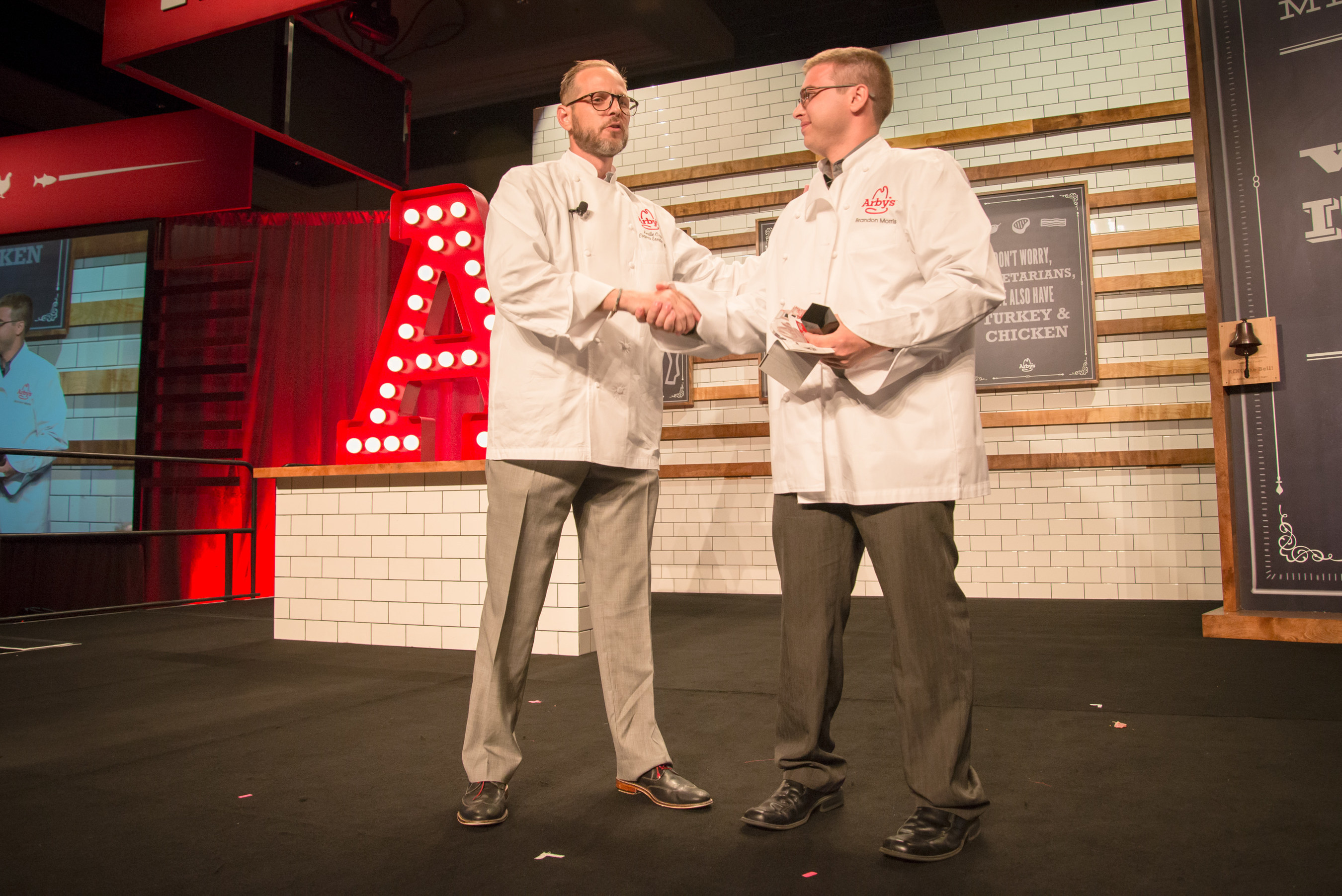 Arby's Corporate Executive Chef, Neville Craw (left), presents the Hey Chef Neville! award to team member, Brandon Morris (right), of Danville, Kentucky at Arby's 2014 Worldwide Franchise Convention in Las Vegas. Morris submitted the winning idea for the King's Hawaiian Fish Deluxe Sandwich, which is being featured at Arby's restaurants nationwide this month as a special menu item. Morris was presented with a trophy, $1,500 check and a custom-made chef coat.