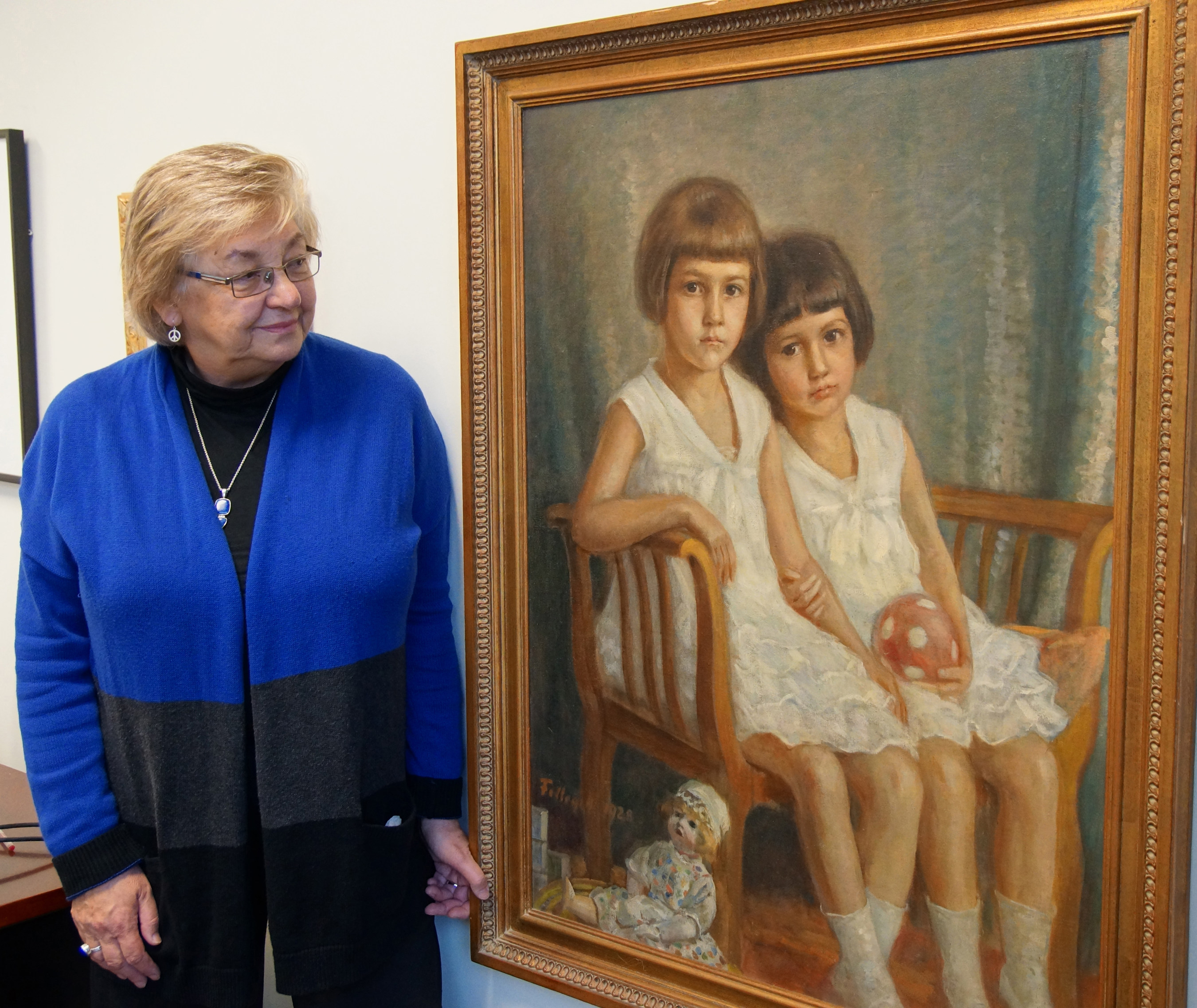 Susan Mikula, Ph.D., acting dean of the College of Liberal Arts at Benedictine University in Lisle, Illinois, stands next to a 1928 oil painting of her mother and aunt that hangs in her office.