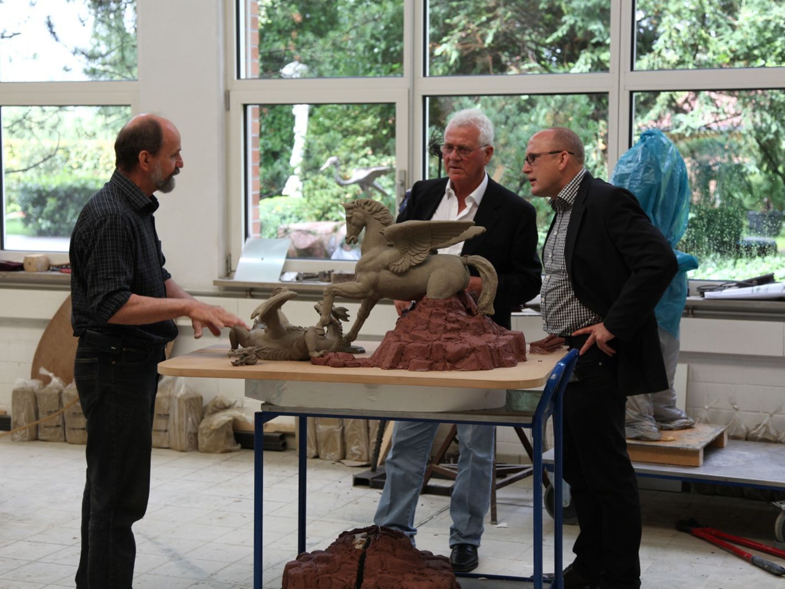 Complete Sculpture of Pegasus and Dragon / Frank Stronach (middle) with Guenter Czasny, deputy managing director from Strassacker, in a conversation with the academic sculptor Waldemar Schroeder (left) at Strassacker workshops. (PRNewsFoto/The Strassacker art foundry)