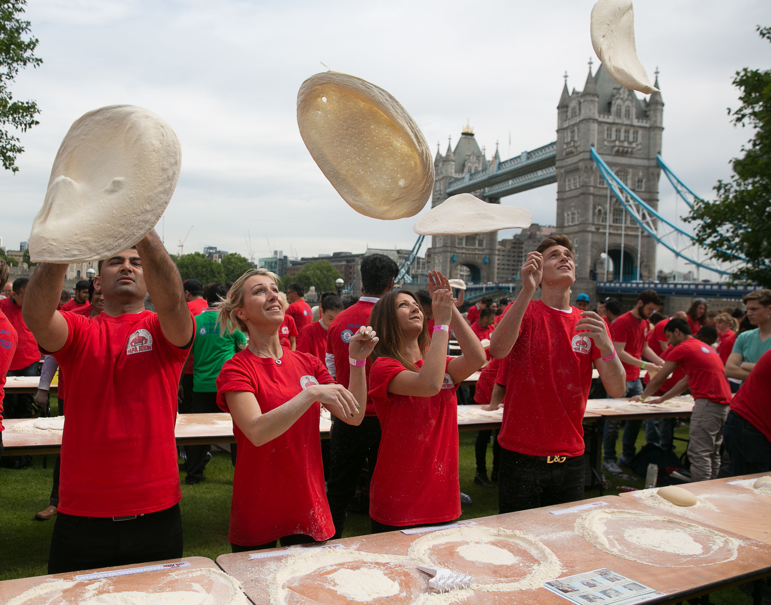 Papa John's employees get stuck in tossing pizza dough as they officially break the GUINNESS WORLD RECORD for the most number of people tossing pizza dough at once. (PRNewsFoto/Papa John's) (PRNewsFoto/Papa John's)