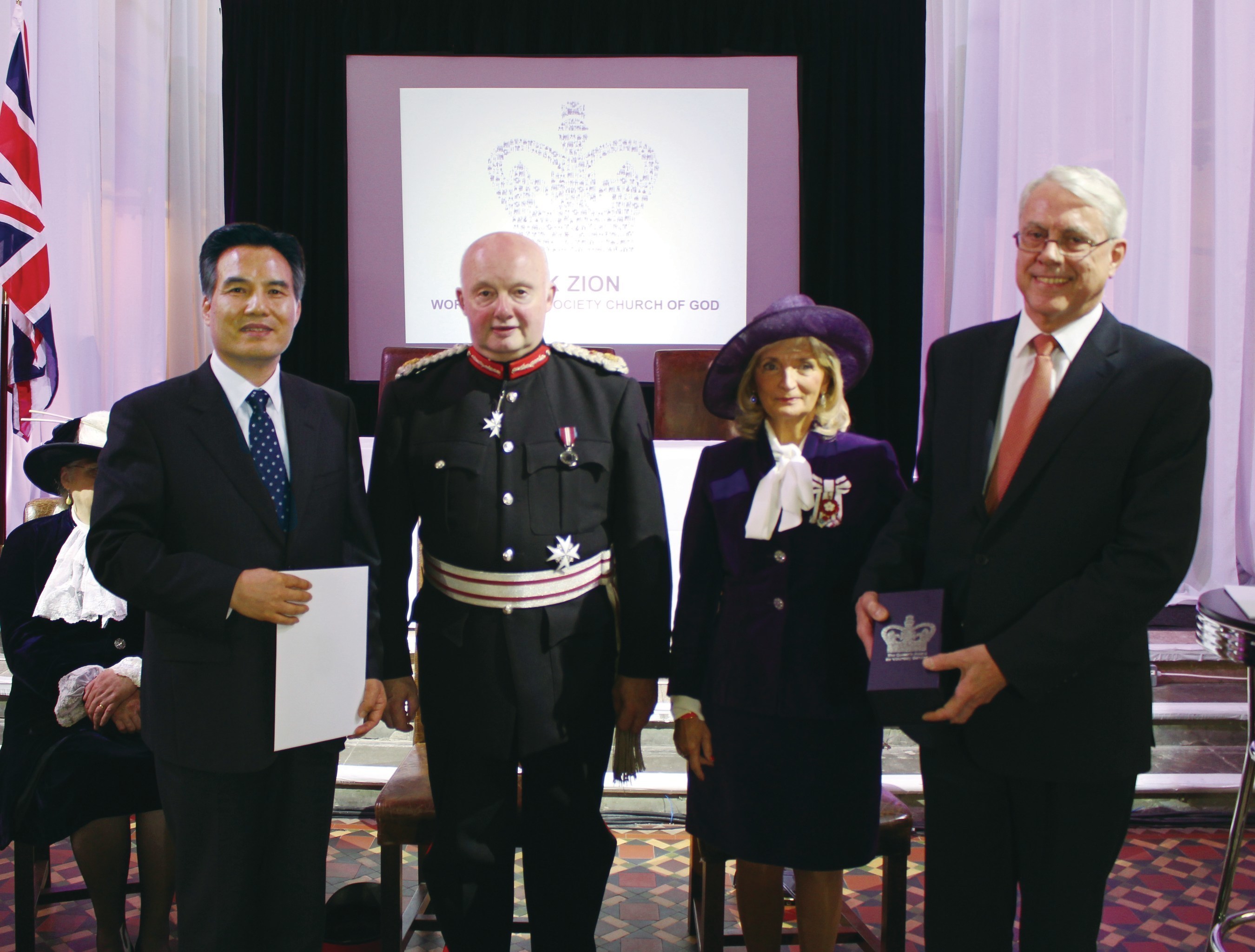 Pastor Kim Joo-Cheol receives the award certificate signed by Queen Elizabeth II and the commemorative crystal of the Queen's Award.