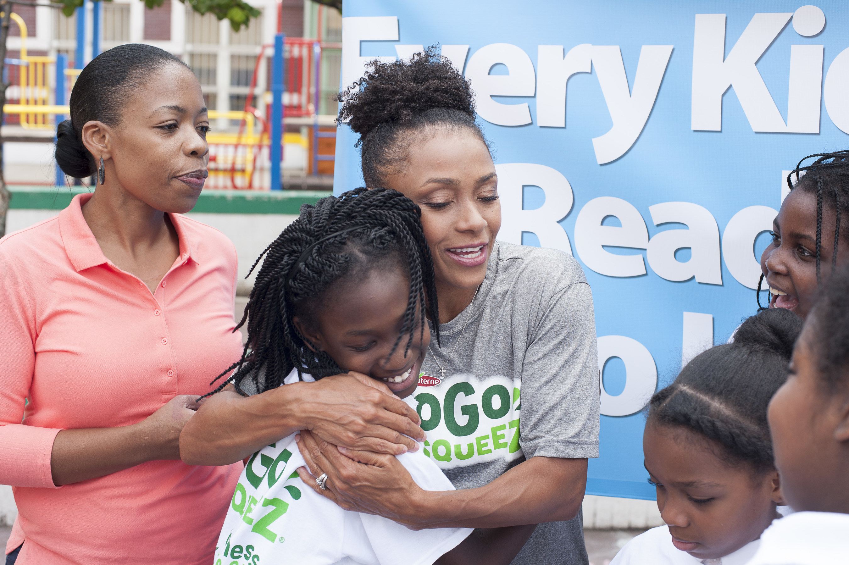 Dominique Dawes, Olympic Gold Medalist and GoGo squeeZ Goodness Ambassador, gives students at P.S. 6 in Brooklyn, NY a squeeZ after leading a workout and announcing a grant to improve access to healthy foods and fitness on behalf of GoGo squeeZ and Action for Healthy Kids on September 21, 2016. (Photo by Phillip Reed).