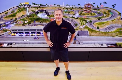Slot Mods founder David Beattie stands in front of one of his handcrafted slot-car raceways.