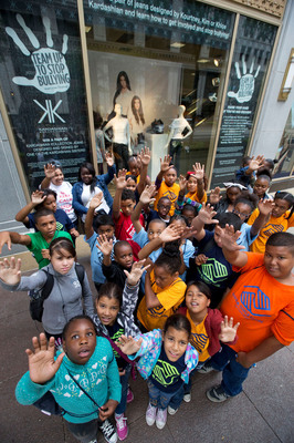 Children from the Boys and Girls Club of Chicago raise their hands to show their commitment to Team Up to Stop Bullying at the Sears State Street store on Monday, August 5, 2013 in Chicago. Sears revealed a window display, featuring jeans designed by Kim, Khloe and Kourtney Kardashian to raise awareness about bullying solutions as students head back to school. The decorated jeans - featuring the autograph and handprint of each celebrity sister to symbolize her commitment to end bullying - will be awarded to winners of a Shop Your Way Rewards sweepstakes, with Sears making a donation to the non-profit charities associated with Team Up to Stop Bullying for every entry. (John Konstantaras / AP Images for Sears).
