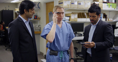 Developers Divya Mahajan from Philips and Brent Blum from Accenture instruct Dr. David Feinstein in how to use the Google Glass connected to IntelliVue monitoring.
