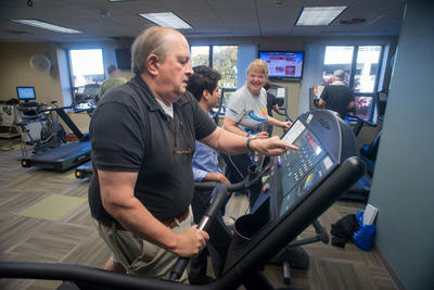 Marcus Dobson (foreground) of Clemmons, N.C., adjusts his machine while Bunny Fontrier (rear) of Winston-Salem, N.C., chats with staff member Hector Hernandez Saucedo during an exercise session at Wake Forest Baptist Medical Center’s Sticht Center for Aging.