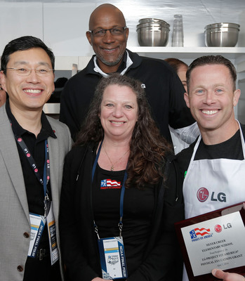 Trey Shearer of Silver Creek Elementary School accepts the award for winning the LG Coaches Cook-Off from William Cho, president and CEO of LG Electronics USA, left, basketball legend Clyde Drexler, back, and Project Fit America Executive Director Stacey Cook, front.