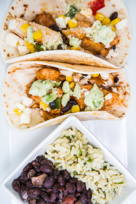 Zona Cocina fresh flavorful food: Blackened Mahi Tacos, twin flour or corn tortillas with roasted corn and black bean relish and avocado creme, with black beans and rice.