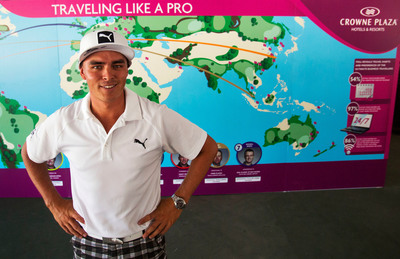 Rickie Fowler stands in front of the Crowne Plaza Invitational at Colonial travel wall.