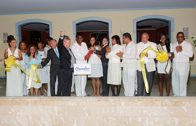 Raising his hand in celebration, Mr. Gordon 'Butch' Stewart, Chairman of Sandals Resorts International, is joined by dignitaries and honored guests to cut the ribbon officially marking the grand opening of the Key West Luxury Village at Beaches Turks & Caicos. (Photo courtesy of Alex Tamargo / Getty Images. All rights reserved.)