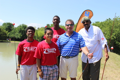 Choice Hotels International President & CEO Stephen P. Joyce and Steve Harvey fish with teens at the Steve Harvey Mentoring Camp for Young Men in Little Elm, TX.