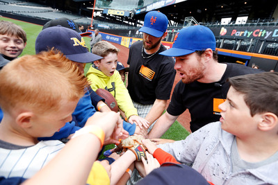 Mets players lead a team cheer at a #ShowYourStripes event at Citi Field.