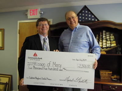 From left to right: Community Bank Executive Chairman of the Board Michael Middleton presents the donation check for Southern Maryland Mission of Mercy to Dr. Garner Morgan.