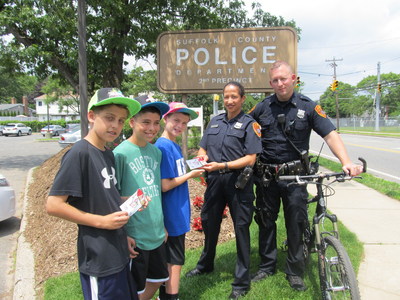 The Suffolk County, Long Island, NY, Police Department (SCPD) is among some 700 law-enforcement agencies in the U.S. participating in 7-Eleven, Inc.-s Operation Chill campaign this year. Police patrol personnel ticket youngsters with a free Operation Chill Slurpee? coupon for good behavior, belonging to a positive community group or helping others. Pictured here are, from left, Suffolk County youngsters Justin Galluzzo, Anthony Johnson and Vincent Milazzo. Providing them with Operation Chill coupons are SCPD community liaison Claudia Delgado and SCPD 2nd Precinct Officer Thomas Collins of the department-s community bike patrol.
