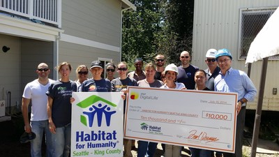 Renton City Councilmember Don Persson joins AT&T and Habitat for Humanity Seattle volunteers for a donation supporting the construction of a 9-unit multi-unit building for local families in need of a home
