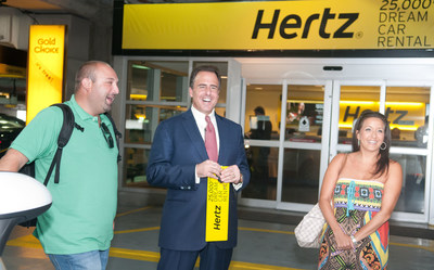 Mark Frissora, Hertz Chairman & CEO, center, celebrates 25,000th Dream Cars rental by surprising customers Mike Yonover and Marissa Yonover on Wednesday, Sept. 3, 2014 in Miami. (Mitchell Zachs/AP Images for Hertz)