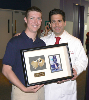 On the one-year anniversary of his donor heart transplant, Jordan Merecka presents his surgeon and friend Dr. David S.L. Morales with a display case holding Jordan's SynCardia Total Artificial Heart and a picture of Jordan's photo on the Times Square JumboTron in New York City.