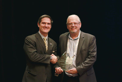 Covanta's Joey Neuhoff (left) receives the Canadian Waste Sector Executive of the Year award from OWMA CEO Robert Cook (right).