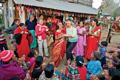 A solo traveler with Overseas Adventure Travel (OAT) shares a dance in Birethanti, Nepal.  Today, 44 per cent of OAT travelers book solo, despite marital status, up from 35% in 2013.  Eight in 10 solo travelers are women.