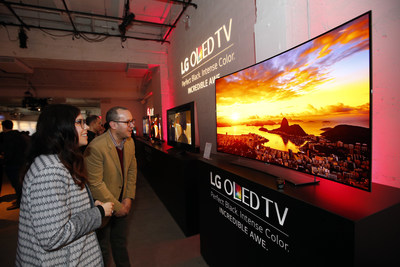 Attendees marvel at an LG 4K UHD OLED TV (Model 65EG9600) at LG and Netflix's "Dare to See OLED" event.