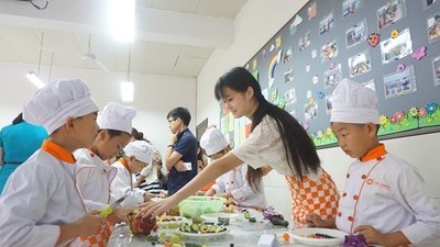 volunteer Jiang Zhaojin instructing students on how to create assorted cold fruit and vegetable dishes