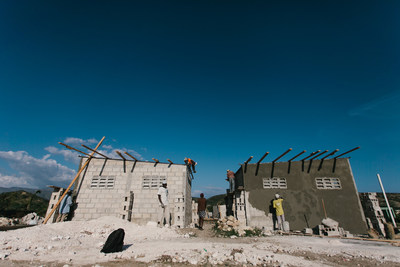 New Story volunteers pictured here constructing new homes in Leveque, Haiti. In the summer of 2015, New Story set out to build 100 new homes in 100 days in areas of Haiti most affected by the 2010 earthquake. The team was able to exceed this goal, completing the 100th house in just 91 days.