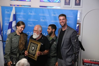 Col. (res.) "Katcha" Cahaner who fought to reunify Jerusalem in the Six day war holds the "Guardian of Zion" award at the Jerusalem day celebration in the FOZ Museum honored by Israeli soldiers and Michael Evans Jr., FOZ Museum CEO