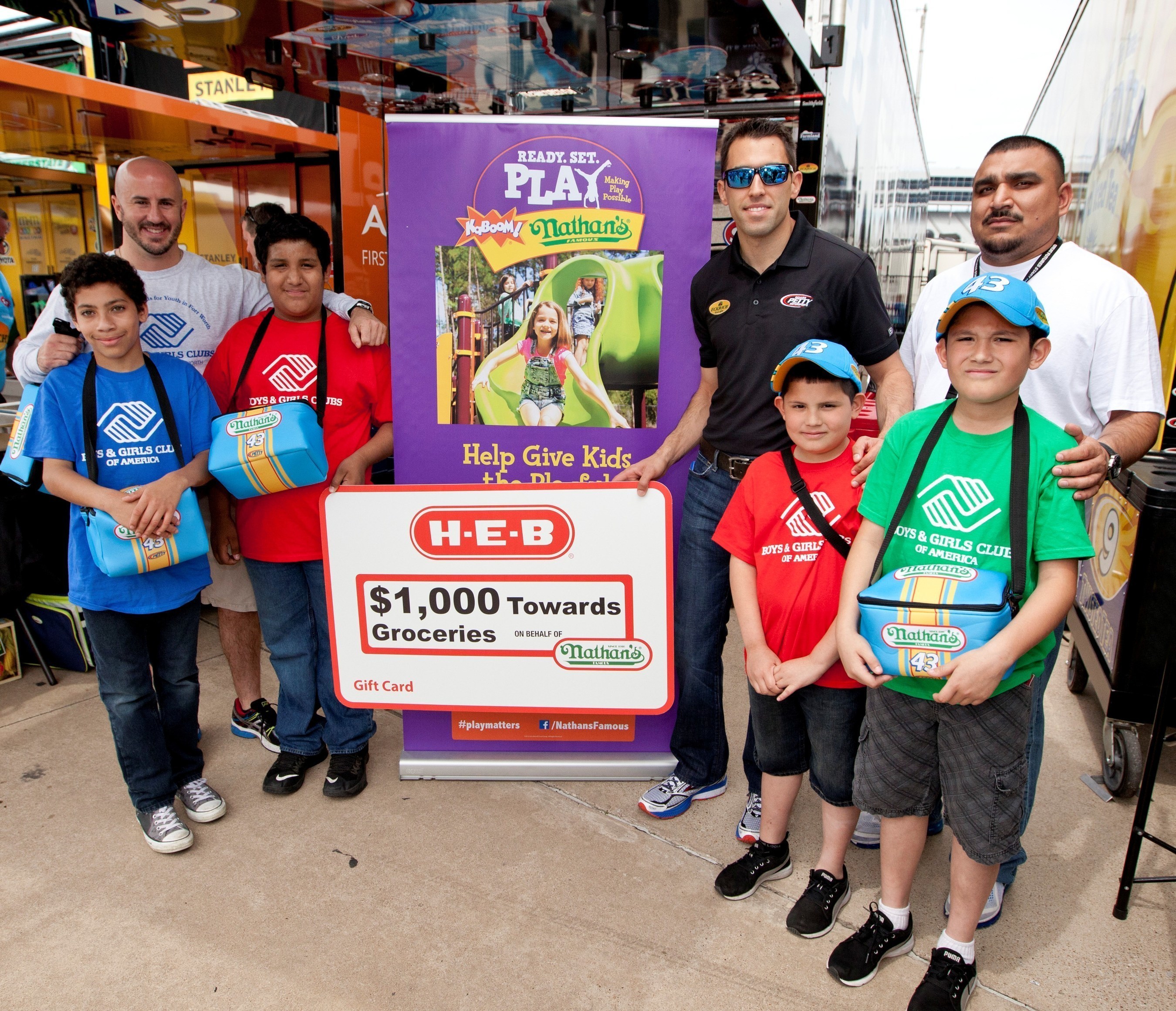 NASCAR driver Aric Almirola presented the Boys & Girls Clubs of Greater Fort Worth with an H-E-B gift card worth $1,000 towards the purchase of groceries, courtesy of Nathan's Famous.