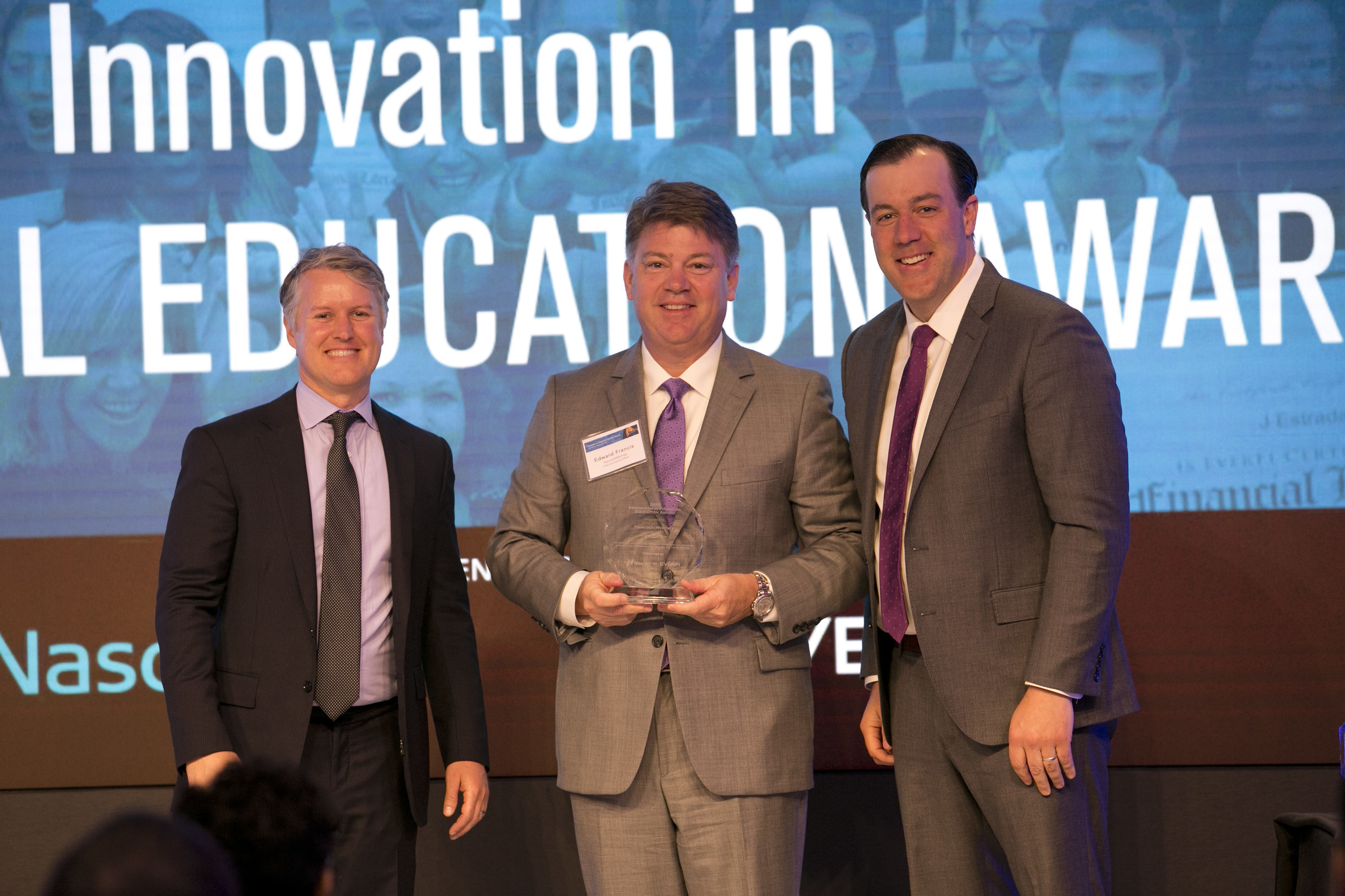 Hancock Holding Company Chief Banking Officer Edward G. Francis (center) accepts the Innovation in Financial Education Award from EverFi, Inc., co-founders CEO Tom Davidson (left) and Chief Strategy Officer Jon Chapman at Nasdaq's Marketsite headquarters in New York City.