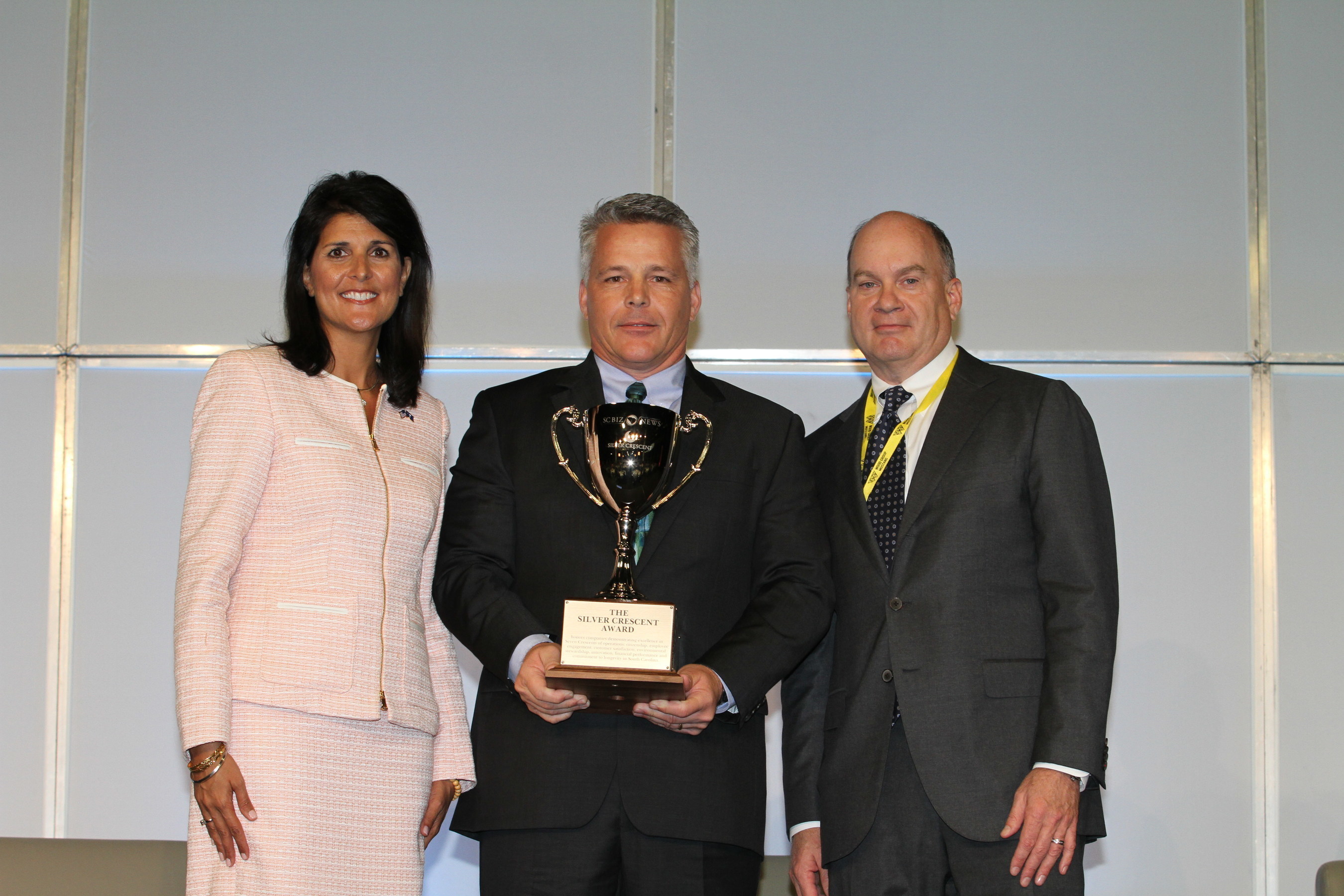 Chris Walsh, Seneca Plant Manager, BorgWarner TorqTransfer Systems (center), accepts a 2015 Silver Crescent Award for Manufacturing Excellence from South Carolina Governor Nikki Haley (left) and H. Lynn Harton, President and Chief Operating Officer, United Community Bank (right), during the South Carolina Manufacturing Conference and Expo.